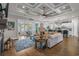 Open-concept living room with hardwood floors, coffered ceilings and a seamless transition to kitchen and outdoor spaces at 2615 Painted Trillium Ct., Myrtle Beach, SC 29579
