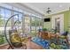 Relaxing sunroom with a hanging chair, comfortable seating, and views of the outdoor landscape at 2615 Painted Trillium Ct., Myrtle Beach, SC 29579