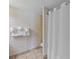 Clean bathroom with shower featuring neutral tile and patterned wallpaper at 2701 N Ocean Blvd. # 561/563, Myrtle Beach, SC 29577