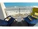 Balcony view of ocean and sandy beach featuring blue lounge chairs and small white table at 2701 S Ocean Blvd. # 1507, North Myrtle Beach, SC 29582