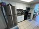 Compact kitchen features stainless steel refrigerator, black appliances, and white cabinetry at 2701 S Ocean Blvd. # 1507, North Myrtle Beach, SC 29582