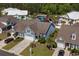 Aerial view showcasing a blue house with neat landscaping and a community water feature at 320 Saint Catherine Bay Ct., Surfside Beach, SC 29575