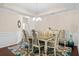 Bright dining room with tray ceiling, chandelier, and large table with seating for eight at 320 Saint Catherine Bay Ct., Surfside Beach, SC 29575