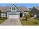 Charming blue home featuring an attached garage and well-maintained front yard at 320 Saint Catherine Bay Ct., Surfside Beach, SC 29575