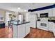 Contemporary kitchen with an island, dark countertops, white cabinets, and an adjacent dining area at 333 14Th Ave. S, Surfside Beach, SC 29575