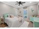 Cozy bedroom with teal accents, featuring a comfortable bed, ceiling fan, and natural light at 355 Oak Ave., Murrells Inlet, SC 29576