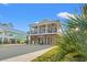 Coastal-style elevated home featuring a double front porch, light gray facade and convenient covered parking at 355 Oak Ave., Murrells Inlet, SC 29576