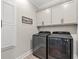 Well-equipped laundry room featuring modern washer and dryer with overhead cabinets for ample storage at 355 Oak Ave., Murrells Inlet, SC 29576