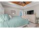 Comfortable main bedroom featuring a tray ceiling with wood panels, a large bed, a dresser, and lots of natural light at 355 Oak Ave., Murrells Inlet, SC 29576