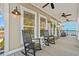 Relaxing front porch with rocking chairs and coastal charm, featuring a light gray facade and ceiling fans at 355 Oak Ave., Murrells Inlet, SC 29576