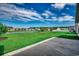 Expansive backyard view with lush lawn, serene lake, and neighboring houses under a clear sky at 377 Copperwood Loop, Conway, SC 29526