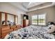 Cozy bedroom featuring a large window, ceiling fan, wood furniture, and comfortable bedding at 377 Copperwood Loop, Conway, SC 29526