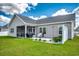 Rear exterior view featuring a screened-in porch, patio area, and well-maintained lawn at 377 Copperwood Loop, Conway, SC 29526