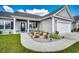 Inviting front yard features a beautifully landscaped garden with colorful flowers and decorative lighting leading to the front door at 377 Copperwood Loop, Conway, SC 29526