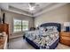 Comfortable main bedroom with large window, tray ceiling, ceiling fan, and plush patterned bedding at 377 Copperwood Loop, Conway, SC 29526