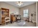 A well lit home office is furnished with a wooden desk, white office chair, and built-in bookshelves at 377 Copperwood Loop, Conway, SC 29526