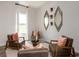 Well-lit sitting room with stylish modern mirrors, three chairs, and a glass coffee table at 4345 Falls Oaks St., Myrtle Beach, SC 29579