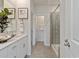 Bright bathroom boasts double sinks with quartz countertops, framed art, and a walk-in shower at 4360 Falls Oaks St., Myrtle Beach, SC 29579