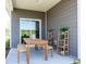 Outdoor patio features a wood table and bench, plant stands, and sliding glass door to the home at 4360 Falls Oaks St., Myrtle Beach, SC 29579