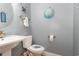 Well-lit blue-painted bathroom with white sink and toilet with matching decorations and brushed nickel fixtures at 524 Cottage Oaks Circle, Myrtle Beach, SC 29579