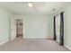 Light green bedroom with tan carpet, ceiling fan, and large window with curtains and a small closet at 524 Cottage Oaks Circle, Myrtle Beach, SC 29579