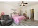 Bright bedroom with hardwood floors, ceiling fan, large windows, comfy chair, and a cozy pink-covered bed at 524 Cottage Oaks Circle, Myrtle Beach, SC 29579
