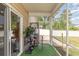 Screened porch with chair, shelving, green turf and view of fenced-in backyard at 524 Cottage Oaks Circle, Myrtle Beach, SC 29579