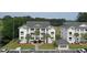 Elegant condos feature white exterior, balconies, lush landscaping, and palm trees providing a serene coastal living experience at 649 Tupelo Ln. # 13A, Longs, SC 29568
