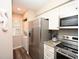 Modern kitchen with stainless steel appliances and adjacent laundry closet at 649 Tupelo Ln. # 13A, Longs, SC 29568