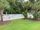 Community pool with white picket fence, palm trees, and lush green landscaping at 649 Tupelo Ln. # 13A, Longs, SC 29568