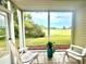 Screened-in porch with golf course view, white adirondack chairs, and tiled flooring at 649 Tupelo Ln. # 13A, Longs, SC 29568