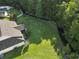 Aerial view of a home with well manicured backyard with lawn, trees, and creek running through the property at 812 Buteo Ct., Myrtle Beach, SC 29588
