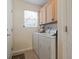 Bright laundry area featuring ample cabinet space, tile flooring, and natural light from the window at 812 Buteo Ct., Myrtle Beach, SC 29588