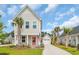 Charming two-story home featuring a delightful coral door, inviting front porch, and well-maintained landscaping at 9012 Mabel Ct., Longs, SC 29568