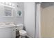 Bathroom with a seashell art piece, neutral paint, toilet, sink with cabinet, and a shower behind a curtain at 9501 Shore Dr. # B-316, Myrtle Beach, SC 29572