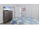 Comfortable bedroom with a surfboard-themed bedspread, a dresser with a TV, and ample closet space at 9501 Shore Dr. # B-316, Myrtle Beach, SC 29572