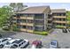 Condo exterior showing screened in balconies with parking lot in the foreground and landscaping in the mid ground at 9501 Shore Dr. # B-316, Myrtle Beach, SC 29572