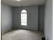 This bedroom boasts neutral paint and a carpeted floor, highlighted by a single arched window at 9739 Leyland Dr. # 12, Myrtle Beach, SC 29572