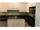 Well-lit kitchen with white cabinets, black countertops, and stainless-steel appliances at 9739 Leyland Dr. # 12, Myrtle Beach, SC 29572