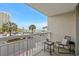 Relaxing condo balcony with seating, views of the beach, and palm trees at 9820 Queensway Blvd. # 105, Myrtle Beach, SC 29572