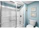 Bright bathroom featuring a shower with sliding glass doors and lovely blue wall decor at 9820 Queensway Blvd. # 105, Myrtle Beach, SC 29572