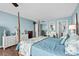 Bright bedroom with light blue walls, four-poster bed, wood flooring, and access to bathroom and closet at 9820 Queensway Blvd. # 105, Myrtle Beach, SC 29572
