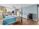 Bedroom featuring four-poster bed, wood flooring, light blue walls, balcony access, and bright, natural light at 9820 Queensway Blvd. # 105, Myrtle Beach, SC 29572