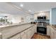 Galley kitchen with granite countertops opening to the living area, with stainless steel appliances and shaker-style cabinets at 9820 Queensway Blvd. # 105, Myrtle Beach, SC 29572