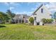 Expansive backyard with a well-maintained lawn, patio, screened-in porch, and a decorative water fountain at 107 Long Bay Golf Pl., Longs, SC 29568