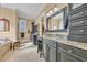 This expansive bathroom features dual vanities, sleek dark cabinetry and a window for natural light at 107 Long Bay Golf Pl., Longs, SC 29568