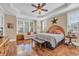 Spacious bedroom with hardwood floors, a decorative ceiling fan, and comfortable seating area by the window at 107 Long Bay Golf Pl., Longs, SC 29568