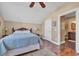 Well-lit bedroom featuring a cozy rattan bed frame and a door leading to an ensuite bathroom at 107 Long Bay Golf Pl., Longs, SC 29568