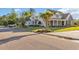 Beautifully landscaped yard with a traditional home in the background and circular driveway at 107 Long Bay Golf Pl., Longs, SC 29568