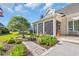 Attractive exterior view of a home with a fountain, colorful garden, and screened-in porch at 107 Long Bay Golf Pl., Longs, SC 29568